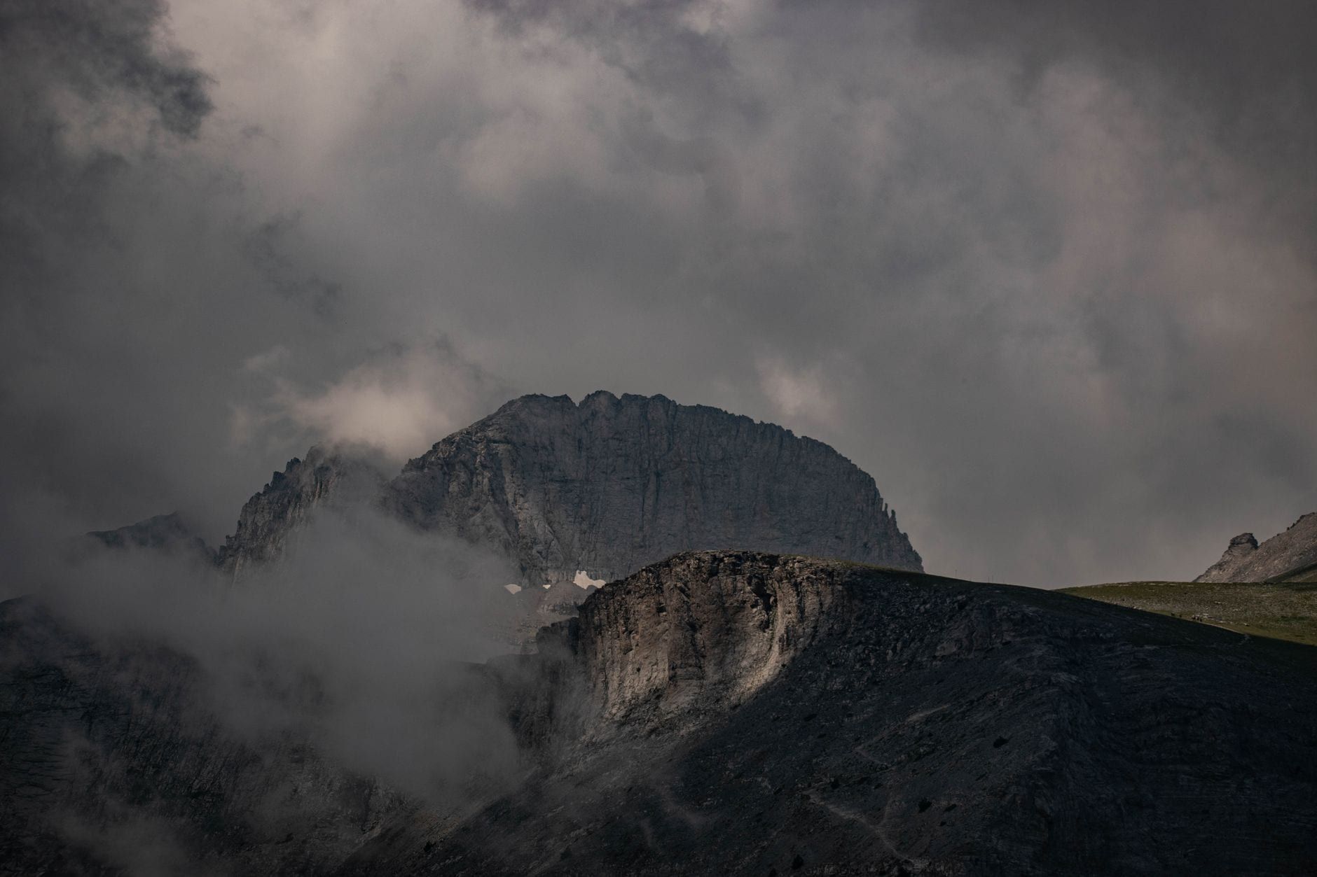 Der felsige, zerklüftete Gipfel des Mount Olympus ragt dramatisch durch umliegende Wolken und Nebel.