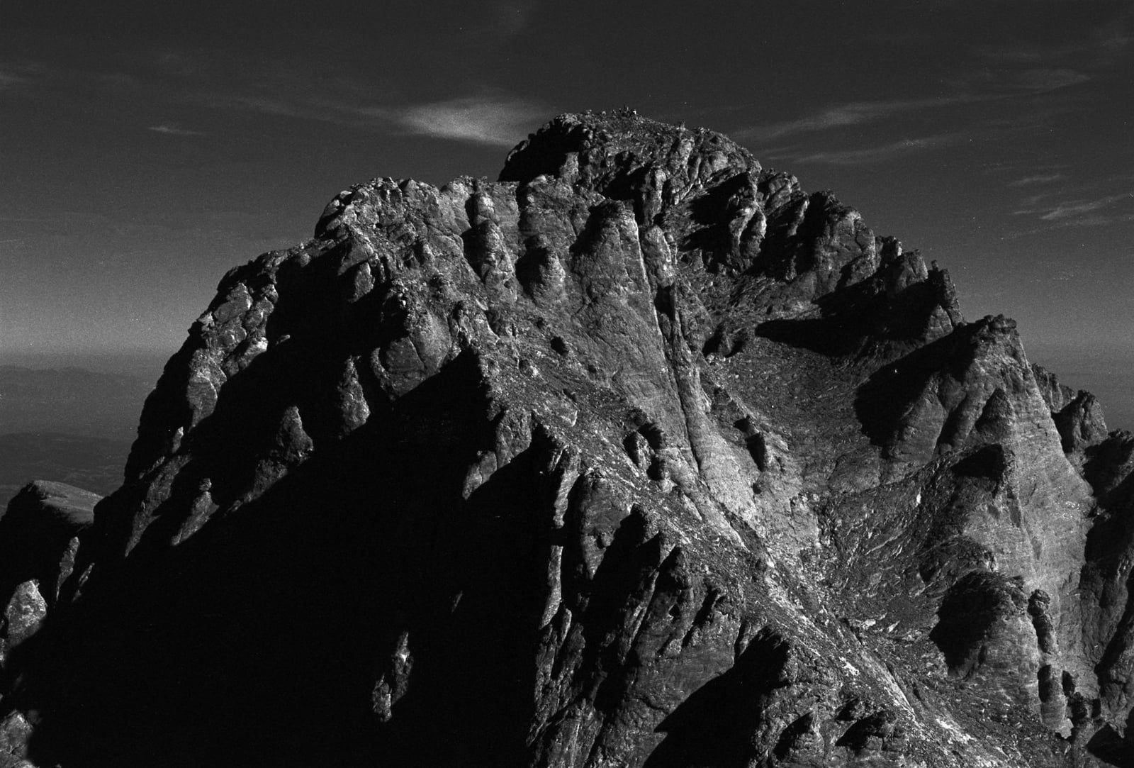 The rugged, rocky summit and steep ridges of Mytikas on Mount Olympus stand sharply defined in black and white.
