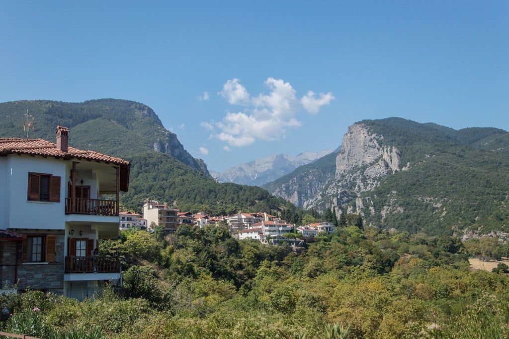 Houses of the village of Litochoro nestled among green hills at the foot of Mount Olympus.